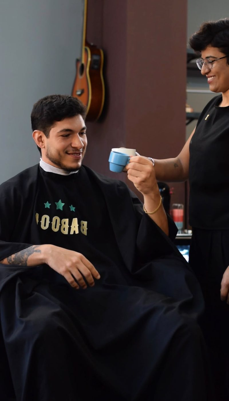Kamilla servindo café para um cliente na cadeira